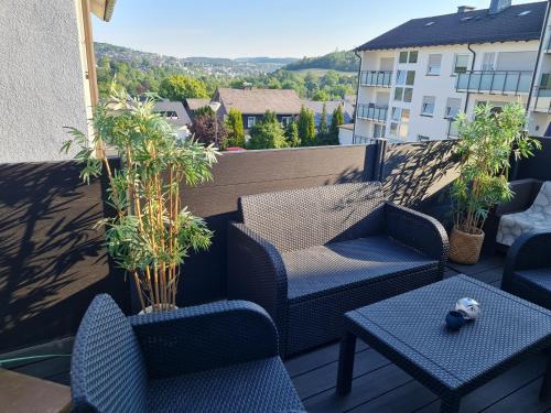 eine Terrasse mit Stühlen und Tischen auf dem Balkon in der Unterkunft Haus SauerlandLiebe in Schmallenberg