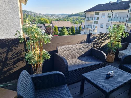 Un patio con sillas y mesas en un balcón. en Haus SauerlandLiebe, en Schmallenberg