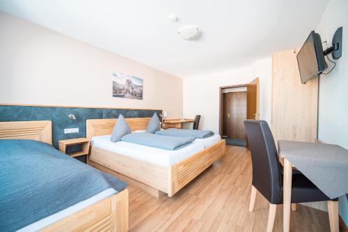 um quarto de hotel com duas camas e uma cadeira em Hotel-Restaurant Langen em Kattenes