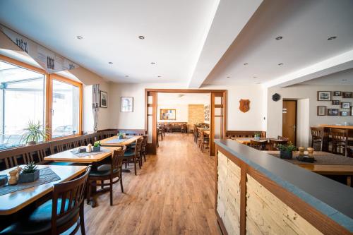 a dining room with wooden tables and chairs at Hotel-Restaurant Langen in Kattenes