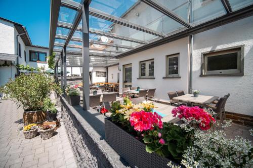 a patio with flowers and a table and chairs at Hotel-Restaurant Langen in Kattenes