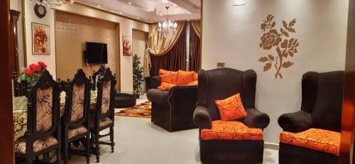 Il comprend un salon avec des chaises et une télévision. dans l'établissement شقة للايجار بفيصل, au Caire