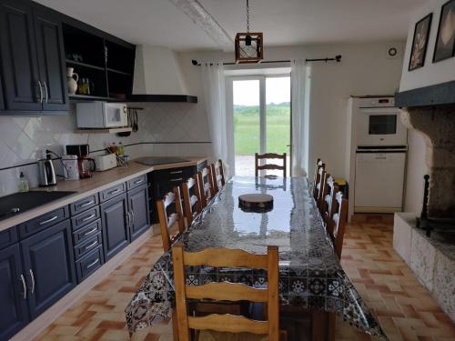 uma cozinha com uma mesa com cadeiras e um balcão em Gite l'Herbier em Conne-de-Labarde