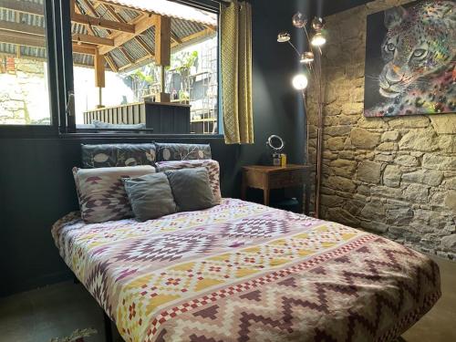 a bedroom with a bed in a room with a stone wall at Un Loft à la mer : Magnifique maison Batz/Mer in Batz-sur-Mer