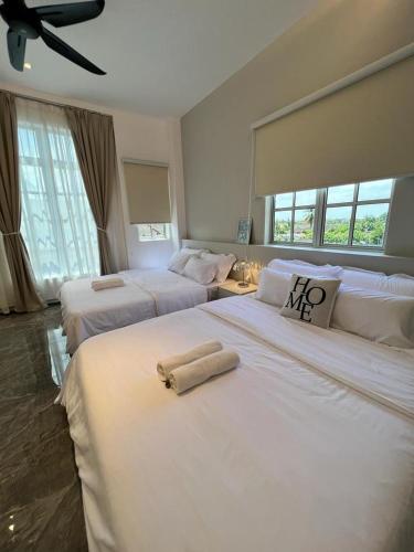 een hotelkamer met 2 bedden en handdoeken erop bij Inn Homestay 2nd Floor Jasmine and Lavender unit in Teluk Intan