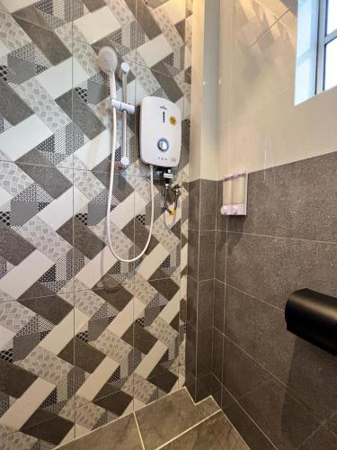 een douche in een badkamer met een tegelvloer bij Inn Homestay 2nd Floor Jasmine and Lavender unit in Teluk Intan