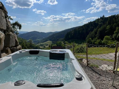 a hot tub with a view of the mountains at Ferienhaus Wendelinus mit Pool & Sauna in Hausach