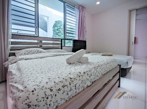 a bedroom with two beds and a large window at Marina Times Square Homestay by Evernent in Miri