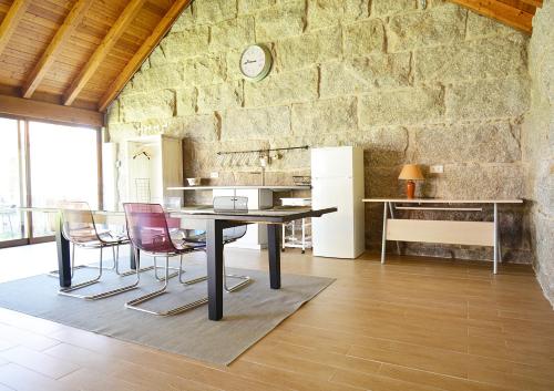 cocina con mesa, sillas y pared de piedra en Casa con precioso jardín en Vilanova de Arousa, en Villanueva de Arosa