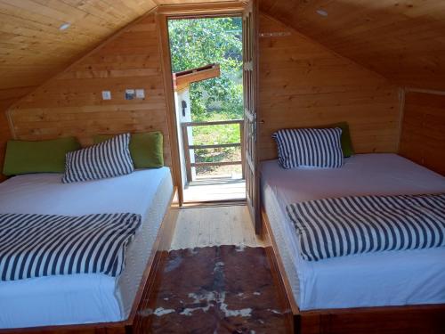 dwa łóżka w pokoju z oknem w obiekcie The Bungalows w Sarajewie
