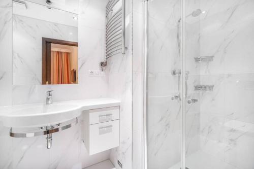 Apartment Imperial في كارلوفي فاري: حمام أبيض مع حوض ودش