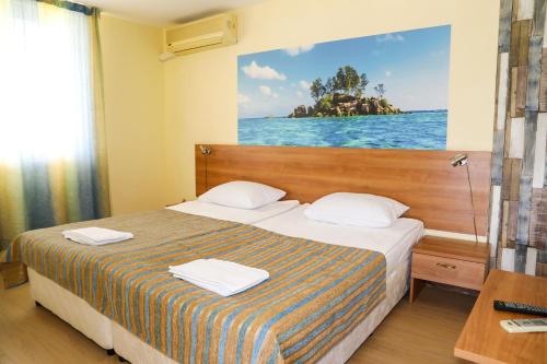 陽光海灘的住宿－Hotel Star，酒店客房的墙上设有一张带照片的床。