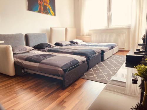 two beds in a room with wooden floors at After Eight Apartment in Bratislava
