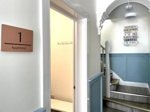 a hallway with a door leading to a stairway at Beachside Apartment 1 Porthcawl in Porthcawl