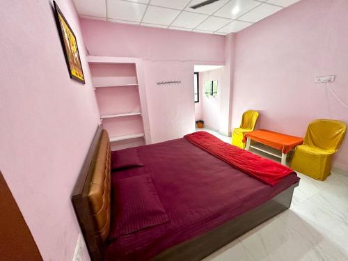 um quarto com uma cama e duas cadeiras em Hotel Tathastu em Rāmtek