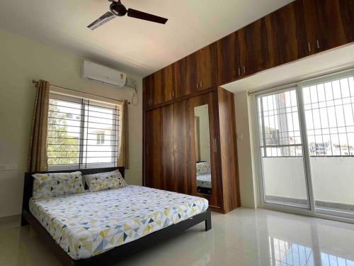 a bedroom with a bed and a ceiling fan at SSN Home Stays in Bangalore near PLAY Arena in Bangalore