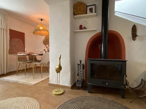a living room with a fireplace and a table at Casa Limonero in Sedella