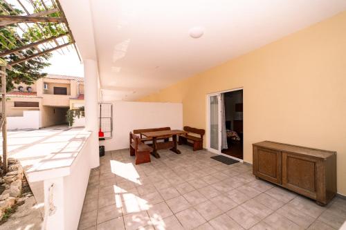 a view of a patio with a table and a bench at Guesthouse Lastavica in Novalja