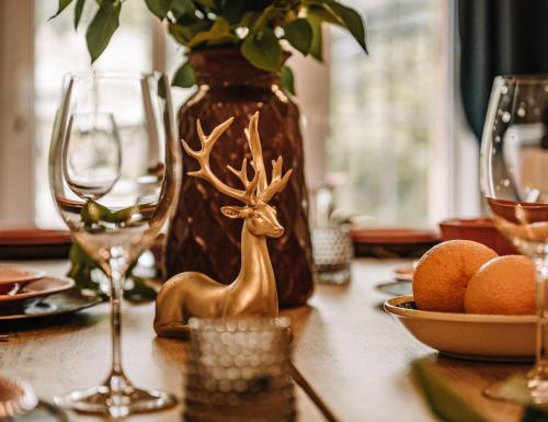 une table avec des verres et une figurine de cerf sur elle dans l'établissement Willa Skalniak, à Lądek-Zdrój