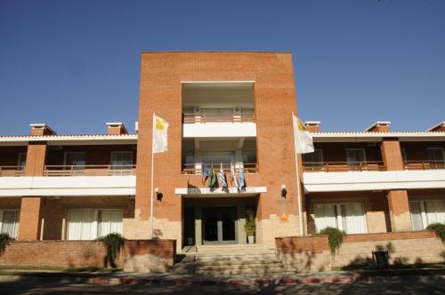 a brick building with flags in front of it at Gran Hotel Fray Bentos in Fray Bentos