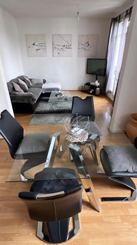- un salon avec des canapés et une table en verre dans l'établissement Appartement 60 m², porte de Saint-Cloud, à Boulogne-Billancourt
