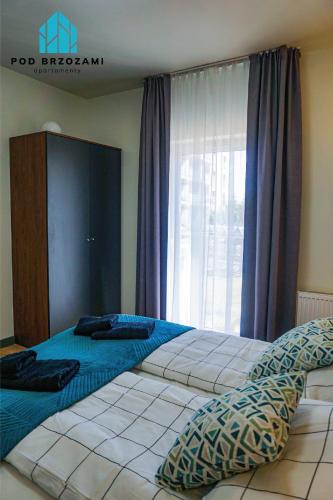a bedroom with two beds and a large window at Pod Brzozami Apartamenty 5 Mórz in Ustronie Morskie