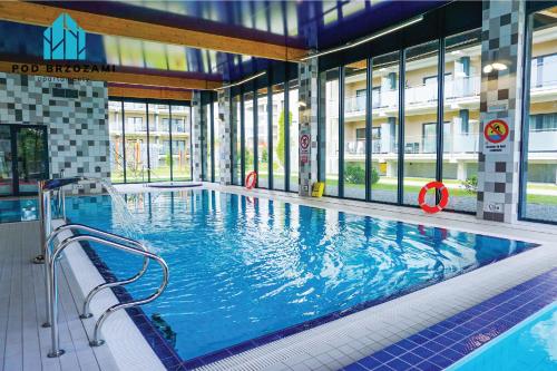 a large indoor swimming pool in a building at Pod Brzozami Apartamenty 5 Mórz in Ustronie Morskie
