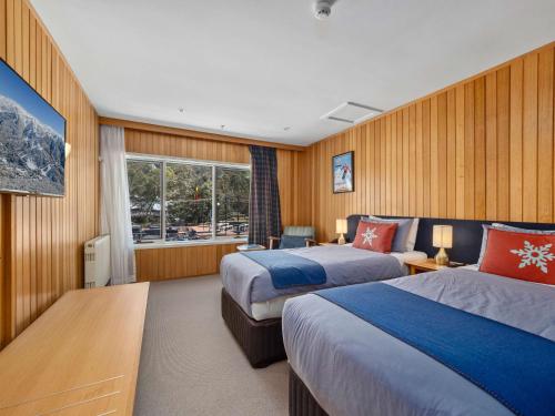 a hotel room with two beds and a window at Thredbo Alpine Hotel in Thredbo