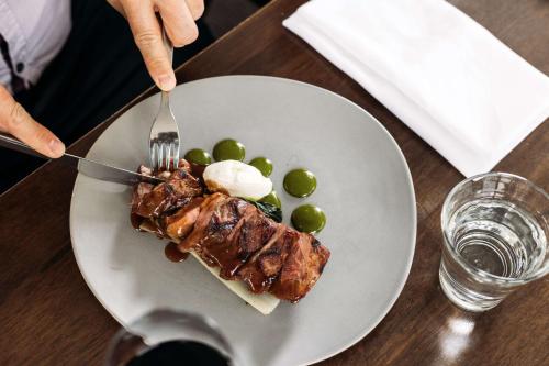 a plate of food with meat and olives on a table at Thredbo Alpine Hotel in Thredbo