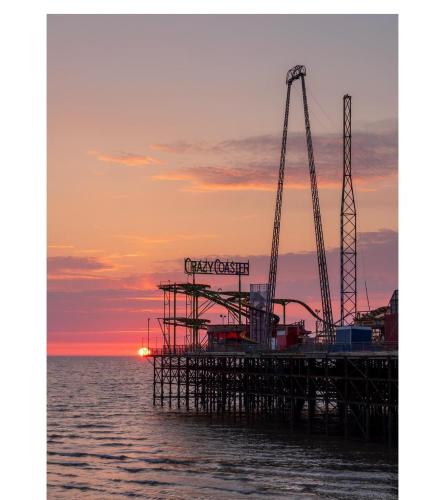 a pier with two cranes in the water at sunset at The Blenheim Mount Hotel in Blackpool
