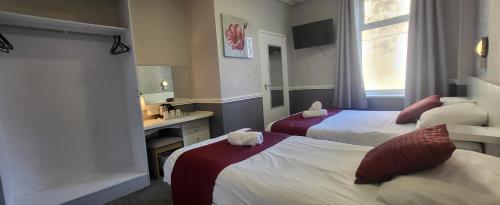 a hotel room with two beds and a sink at The Blenheim Mount Hotel in Blackpool