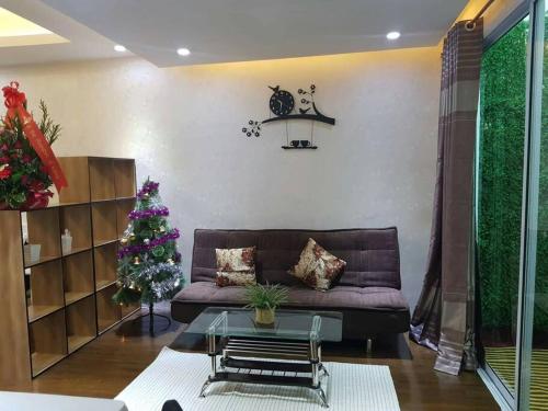 a living room with a couch and a christmas tree at Muong Thanh Luxury Condo 5min walk to Thai Consular in Vientiane