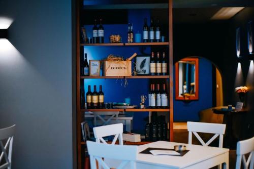 uma mesa e cadeiras numa sala com garrafas de vinho em Hotel Skala em Belgrado