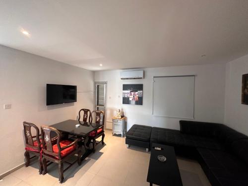 a living room with a black couch and a table at Seaside Apartments in Paphos City
