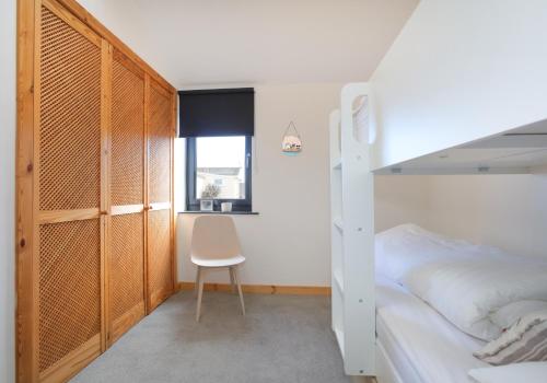 a bedroom with a bunk bed and a chair at Belle Haven Chalet. in Dunbar
