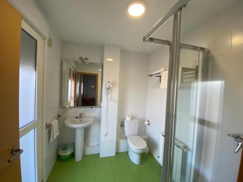 a bathroom with a toilet and a sink and a shower at Pensión Abeledo in Sarria