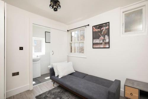 uma sala de estar com um sofá preto num quarto em Spacious Serenity in the Heart of Central London em Londres