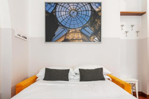 a bedroom with a white bed with a stained glass ceiling at Da Simone sui Navigli in Milan