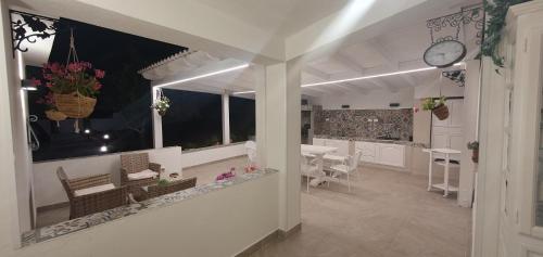 a kitchen and dining room with a clock on the wall at Villa Antonella - Pool and Sea view in Castellammare del Golfo