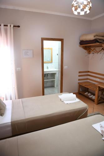 a bedroom with two beds and a mirror at Guesthouse Leo in Berat