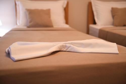 a white robe sitting on top of a bed at Guesthouse Leo in Berat