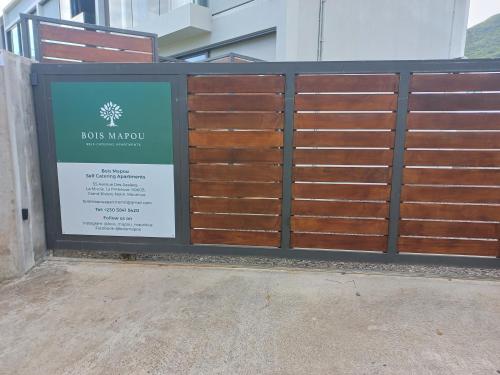 a gate with a sign in front of a building at Bois Mapou Self Catering Apartments Unit 103 in Rivière Noire