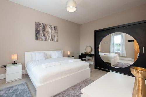 a bedroom with a large white bed and a mirror at Ashtree Farm in Durham