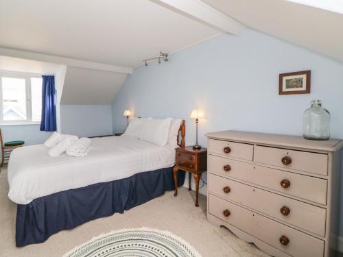 27 Exeter Street في تيغنماوث: غرفة نوم مع سرير وخزانة