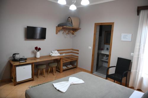 a room with a table and a desk with a television at Guesthouse Leo in Berat