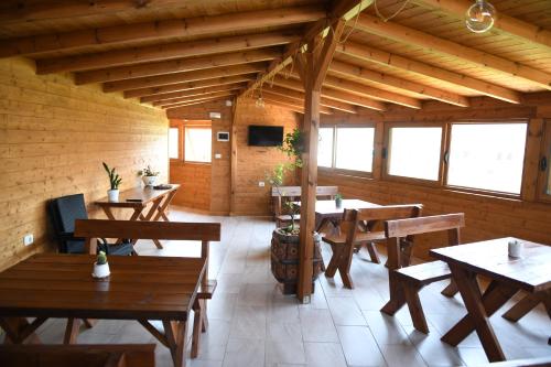 a restaurant with wooden tables and chairs in a room at Guesthouse Leo in Berat