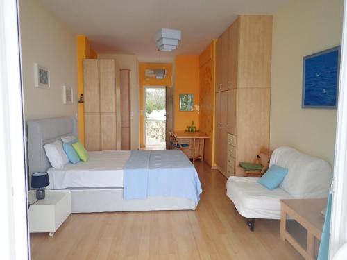 um quarto grande com 2 camas e um sofá em Beachfront Studio with Private Path to the Sea em Poros
