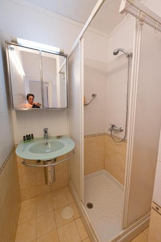 a bathroom with a sink and a shower at Beachfront Studio with Private Path to the Sea in Poros