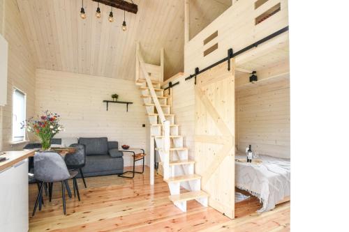 a tiny house with a staircase and a bedroom at Pogodny domek in Kołczewo