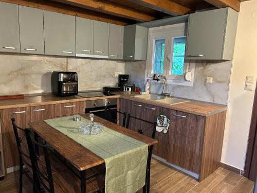 una cucina con tavolo, forno a microonde e lavandino di Green Olive Studios 2 a Agios Mamas